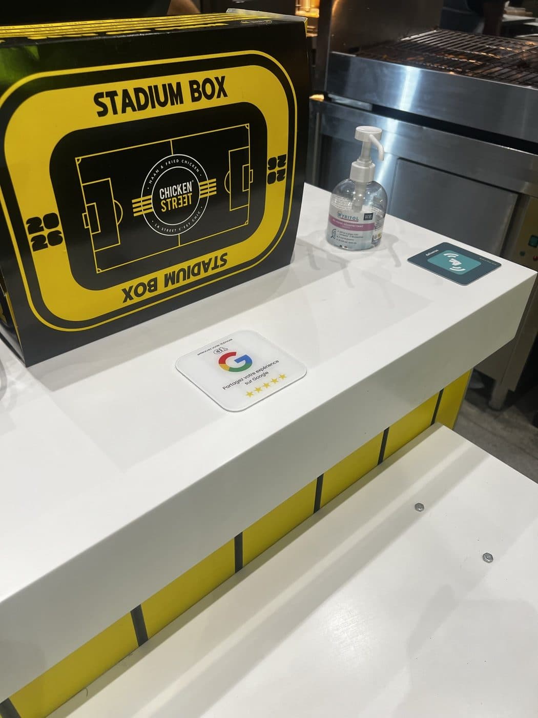 Plaque Avis Google installée sur le comptoir du restaurant Chicken Street